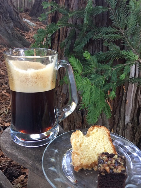 Stein of beer next to a plate of desserts